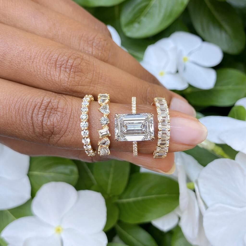 three diamond engagement rings and loose diamond shapes worn on ladies hand